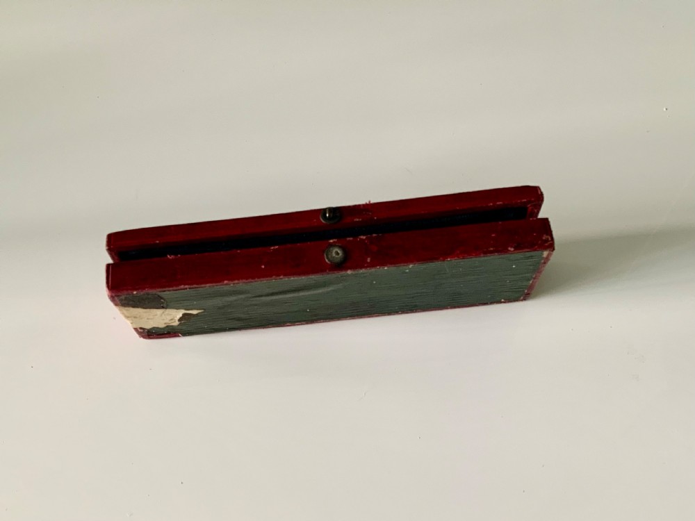 A boxed Georgian sterling silver childs knife and three-tined fork with shell motifs on the handles, displayed below a red fitted presentation case. View VI