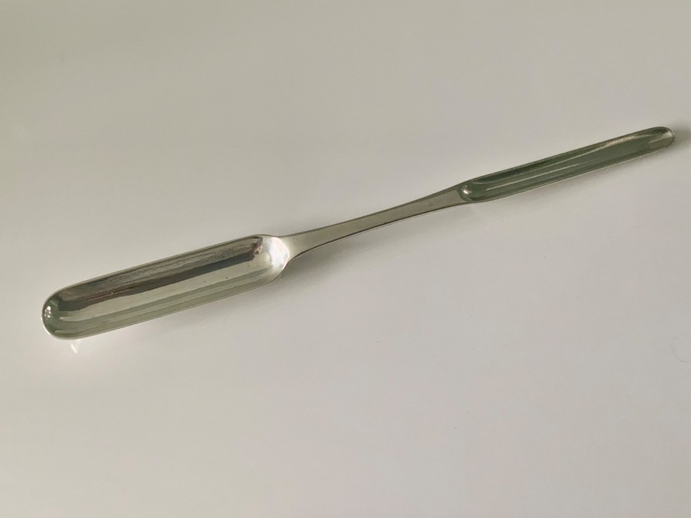 An antique double-ended sterling silver marrow scoop featuring two elongated trough-shaped bowls of differing widths connected by a narrow central shank.