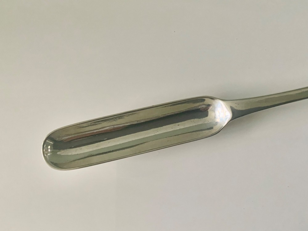 An antique double-ended sterling silver marrow scoop featuring two elongated trough-shaped bowls of differing widths connected by a narrow central shank. View IV