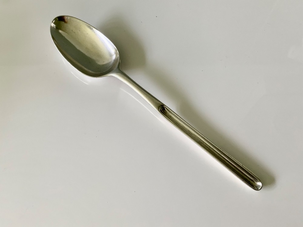 A sterling silver Georgian marrow spoon featuring an oval spoon bowl at one end transitioning into a narrow grooved scoop along the stem.