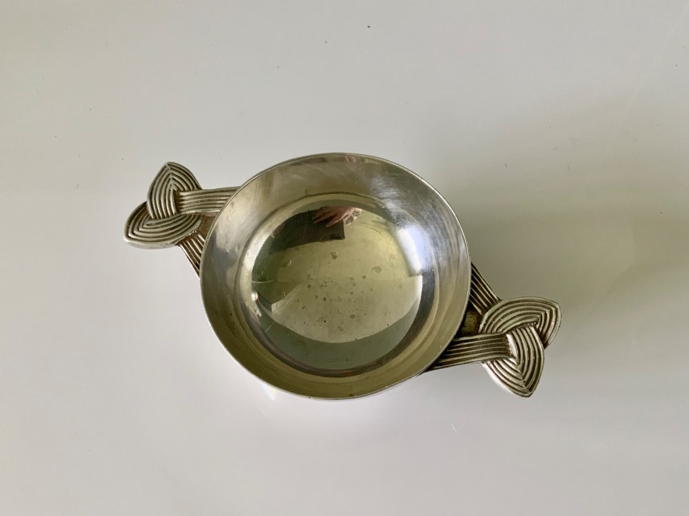 A shallow sterling silver quaich featuring two textured Celtic knot handles and visible hallmark stamps on the outer bowl. View II