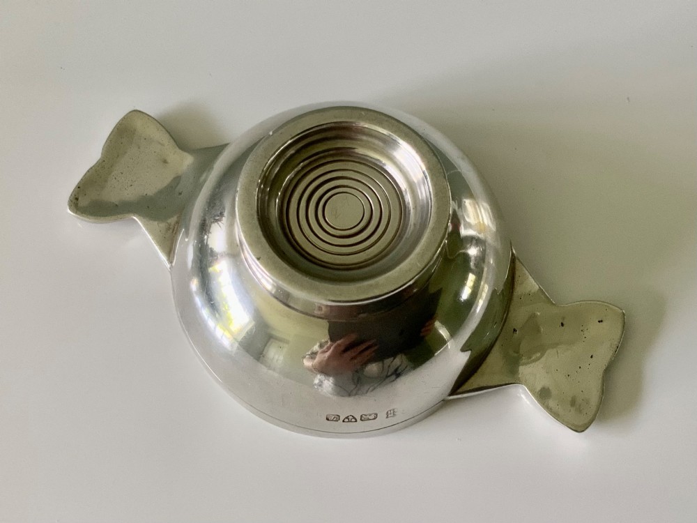 A shallow sterling silver quaich featuring two textured Celtic knot handles and visible hallmark stamps on the outer bowl. View III