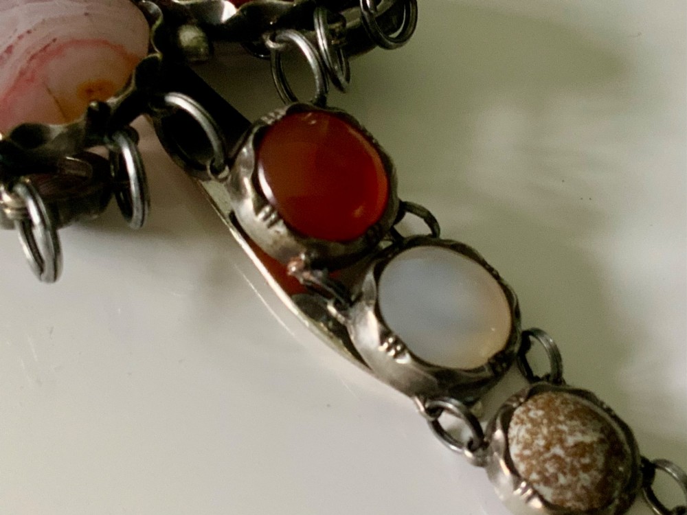 A Victorian silver chatelaine clip set with polished oval and circular multicolour agates and jaspers arranged in three articulated drops. View IV