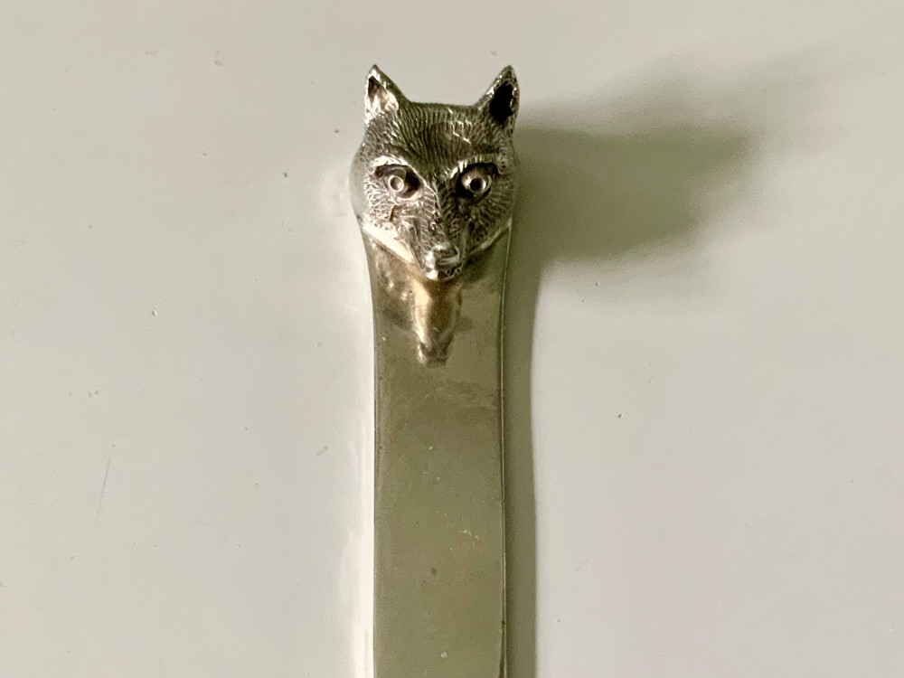 An antique sterling silver letter opener featuring a flat tapered blade and a detailed cast fox head terminal. View II