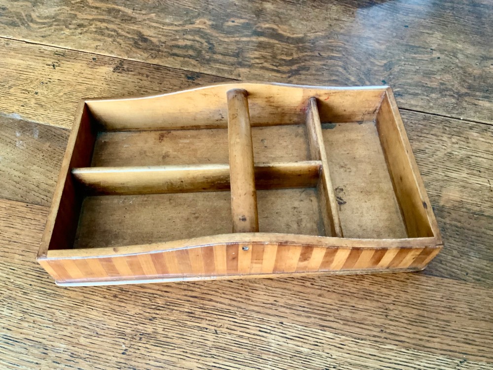 A nineteenth-century Scottish wooden cutlery tray with divided internal compartments, a turned cylindrical handle, and striped timber inlay along the exterior.