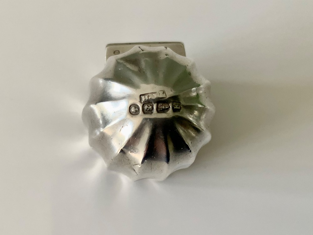 A small fluted sterling silver vinaigrette box featuring official hallmarks stamped onto its curved top section. View II
