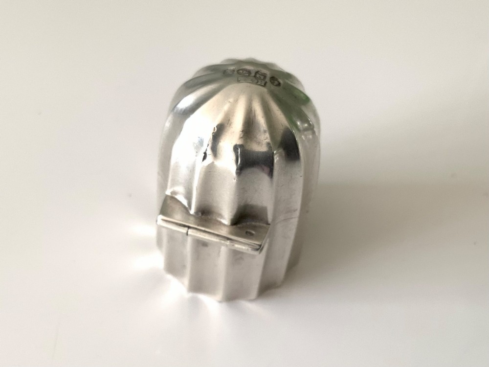 A small fluted sterling silver vinaigrette box featuring official hallmarks stamped onto its curved top section. View IV