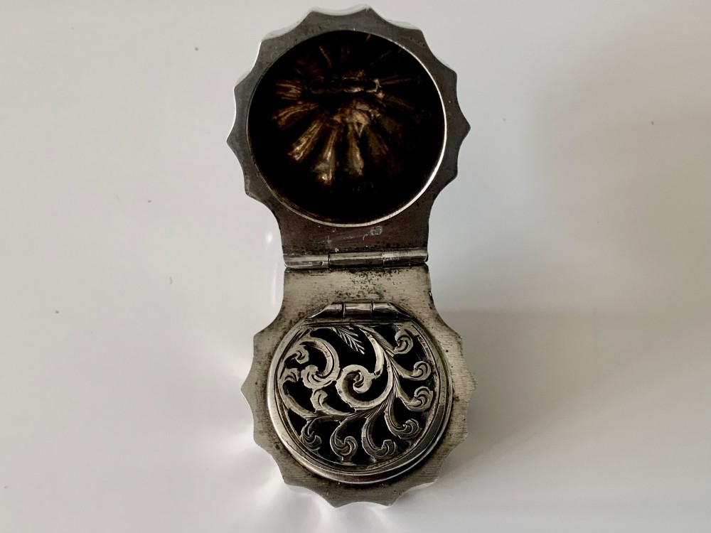 A small fluted sterling silver vinaigrette box featuring official hallmarks stamped onto its curved top section. View VI