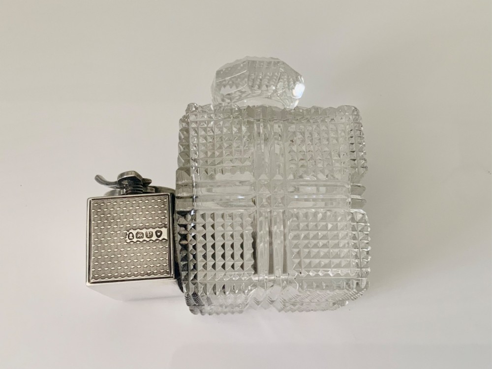 A square geometric cut glass travelling inkwell with a hallmarked sterling silver hinged lockdown mechanism attached alongside. View V