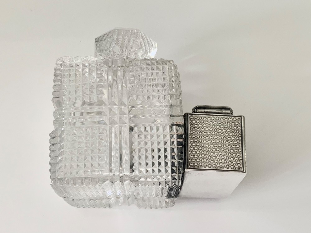 A square geometric cut glass travelling inkwell with a hallmarked sterling silver hinged lockdown mechanism attached alongside. View VIII