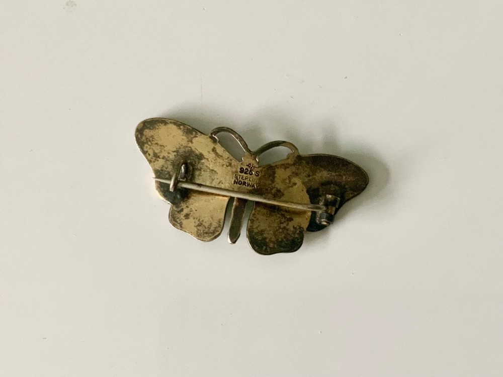 A silver brooch designed as a butterfly with pale green guilloche enamel wings edged in burgundy. View II