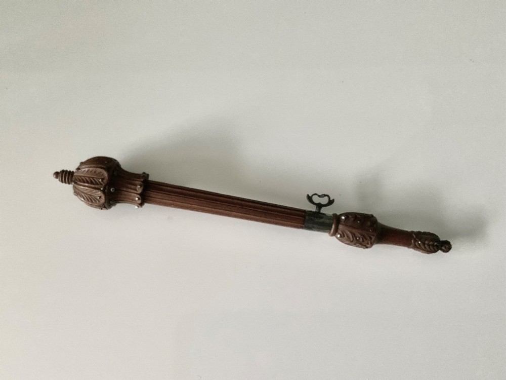 A carved wooden tambour needle handle featuring ribbed fluting, leaf motifs, cut steel stud ornamentation, and a metal thumbscrew. View II