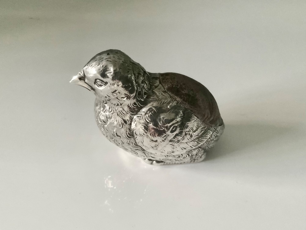 An antique sterling silver pin cushion cast in the shape of a chick with chased feather detail and a brown velvet inset cushion. View II