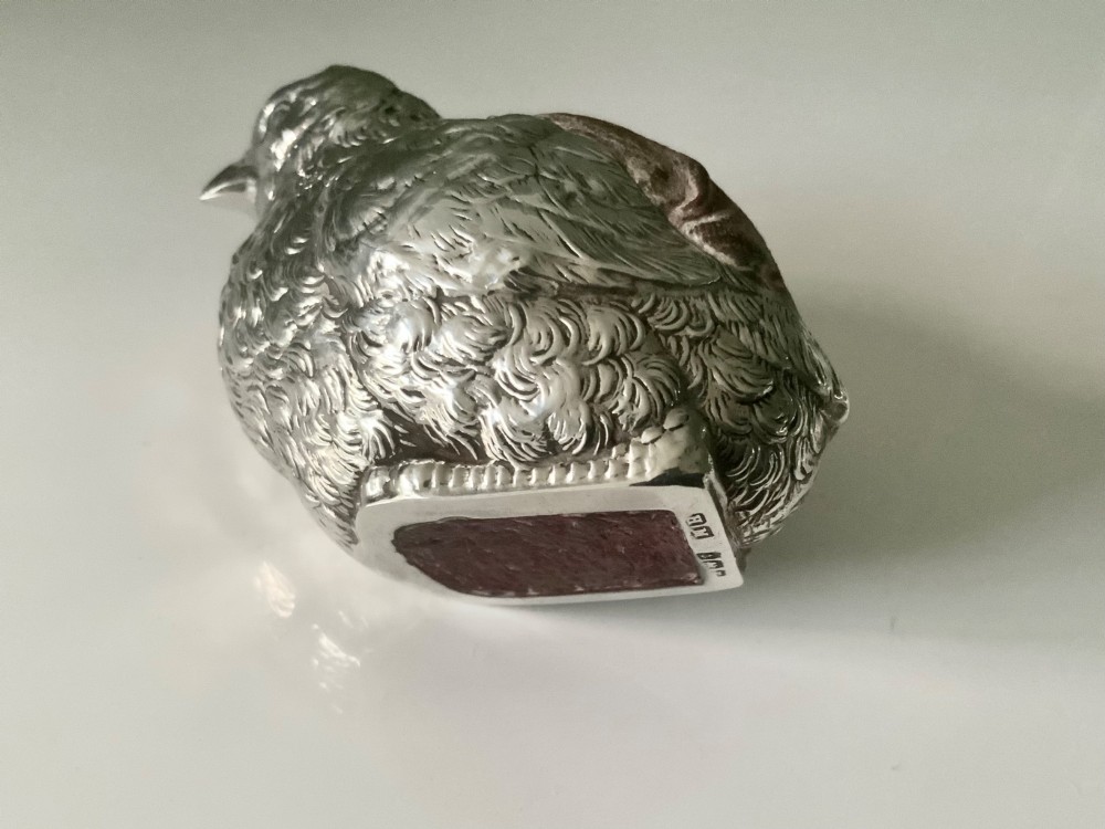 An antique sterling silver pin cushion cast in the shape of a chick with chased feather detail and a brown velvet inset cushion. View IV