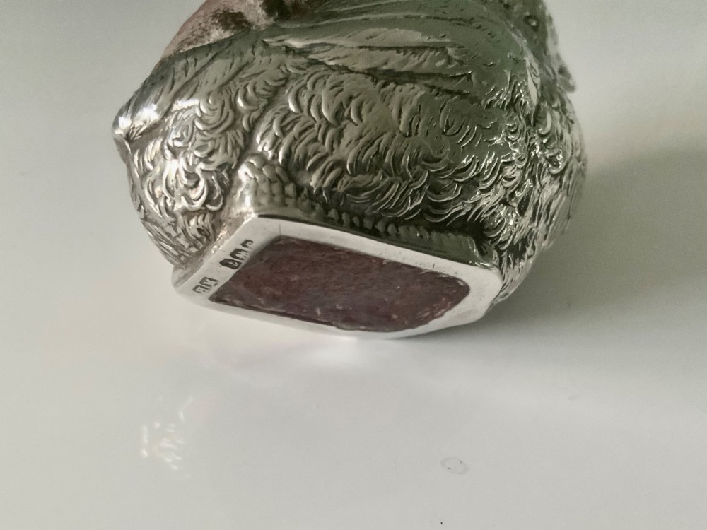 An antique sterling silver pin cushion cast in the shape of a chick with chased feather detail and a brown velvet inset cushion. View V