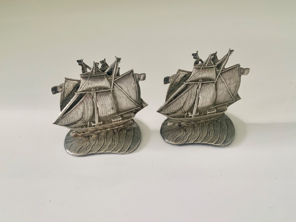 A pair of silver menu holders cast in the shape of three-masted galleon ships set atop ocean wave bases featuring stamped hallmarks. View II
