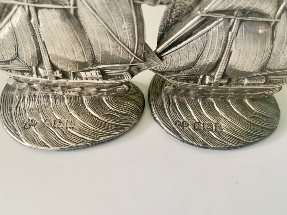 A pair of silver menu holders cast in the shape of three-masted galleon ships set atop ocean wave bases featuring stamped hallmarks. View III