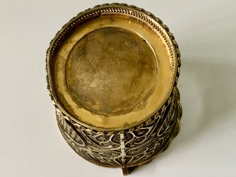A small cylindrical silver gilt filigree basket with a twisted swing handle and intricate openwork lacelike patterns. View IV