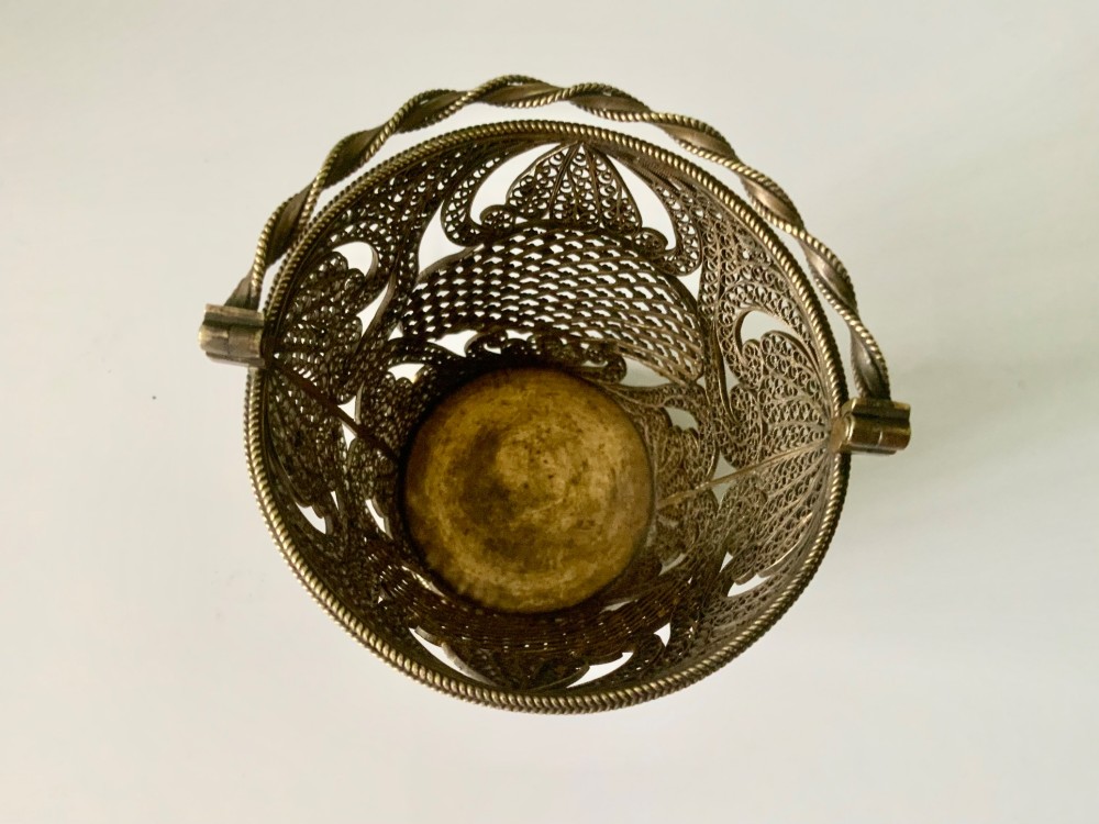A small cylindrical silver gilt filigree basket with a twisted swing handle and intricate openwork lacelike patterns. View V