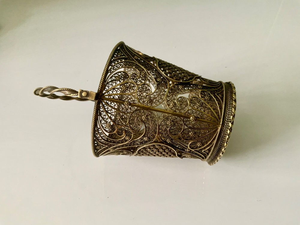 A small cylindrical silver gilt filigree basket with a twisted swing handle and intricate openwork lacelike patterns. View VI