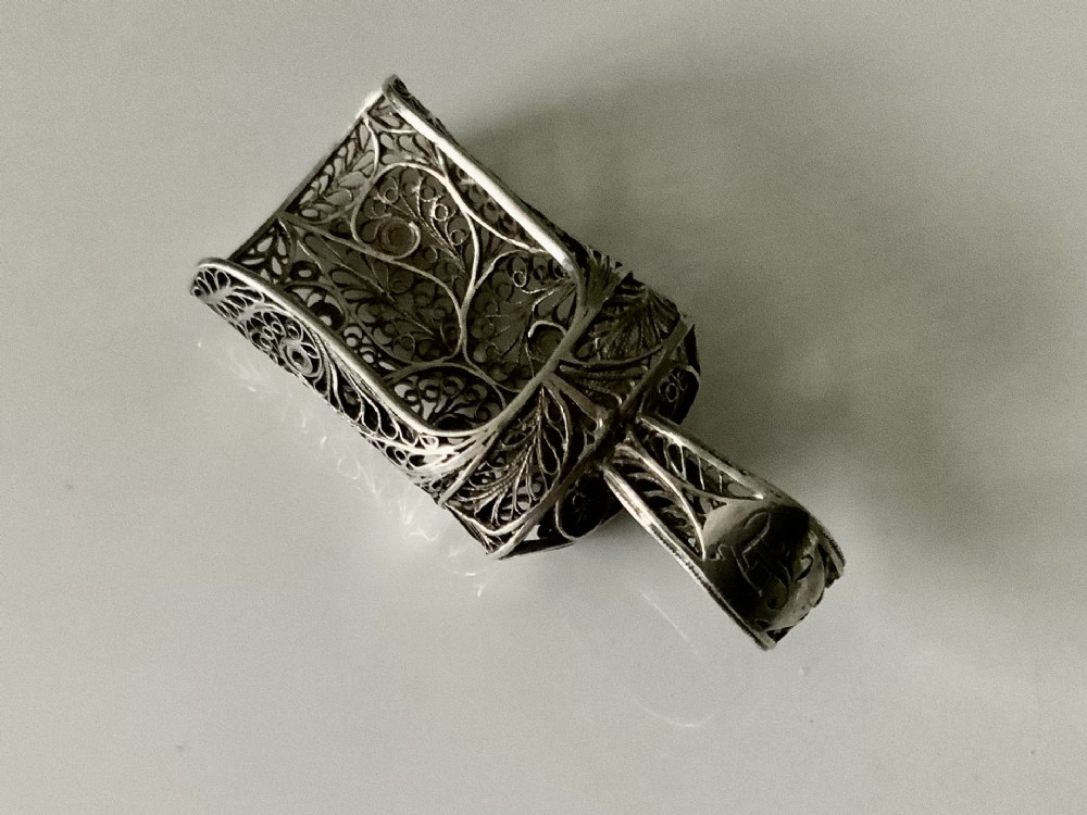 An antique Georgian silver filigree tea caddy spoon featuring intricate openwork scroll patterns and an engraved monogram cartouche on the loop handle. View II