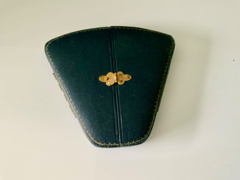 A set of six silver cocktail sticks featuring colourful enamelled cockerel finials, displayed inside an open fitted fan-shaped blue leather case. View IV