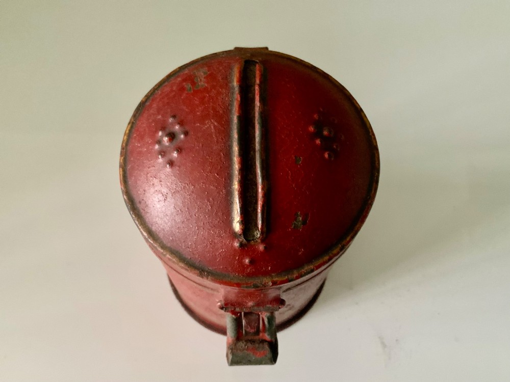 A cylindrical red painted toleware money box dated 1818 featuring a domed top with coin slot, metal latch, and gilded leaf decoration. View III