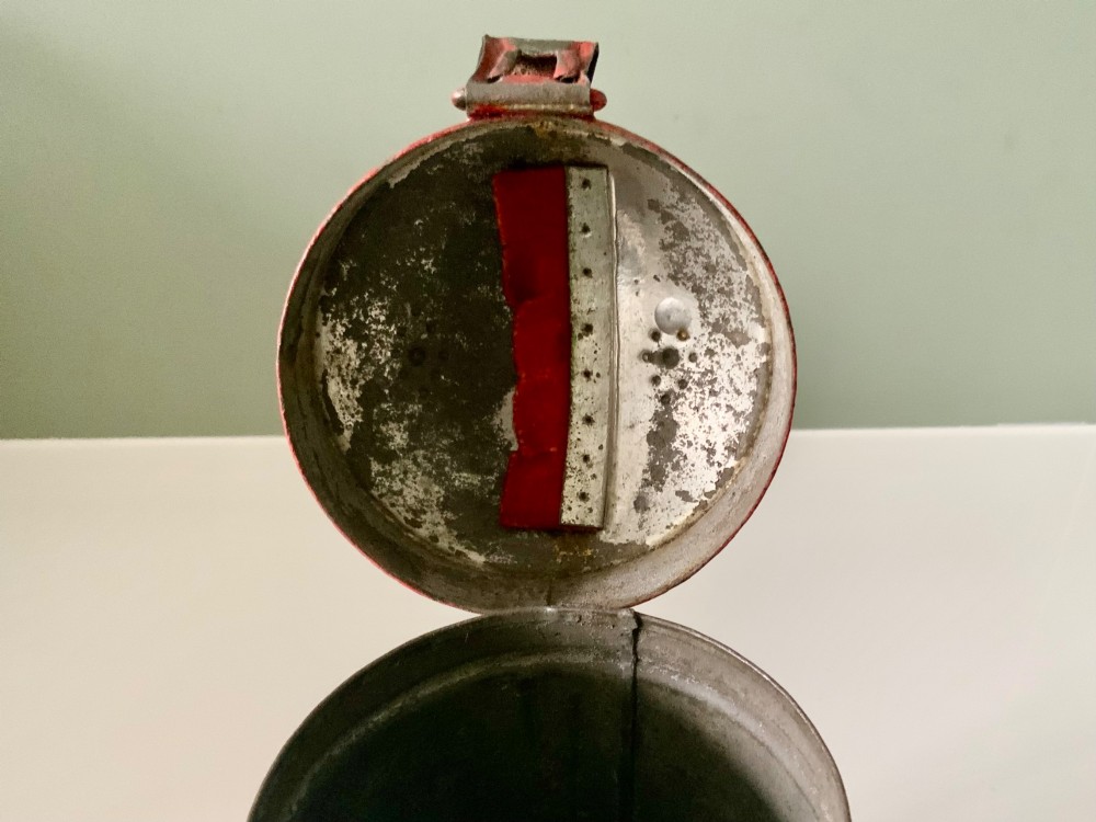 A cylindrical red painted toleware money box dated 1818 featuring a domed top with coin slot, metal latch, and gilded leaf decoration. View VII