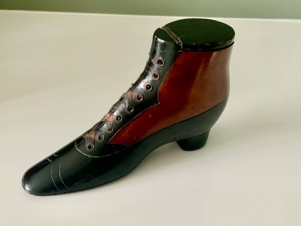 A carved wooden snuff box formed in the shape of a Victorian laced boot with polished black and natural timber finishes. View II