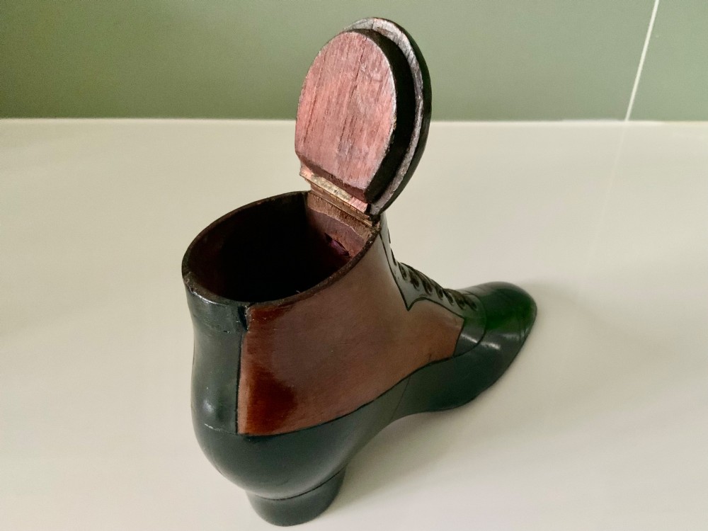 A carved wooden snuff box formed in the shape of a Victorian laced boot with polished black and natural timber finishes. View V
