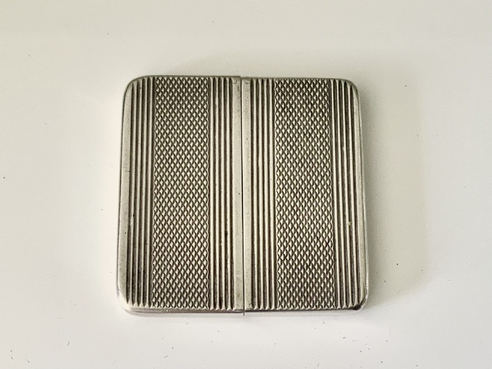 An Art Deco silver travelling photograph frame with engine-turned geometric patterns on the sliding outer panels, displaying a black and white portrait. View III