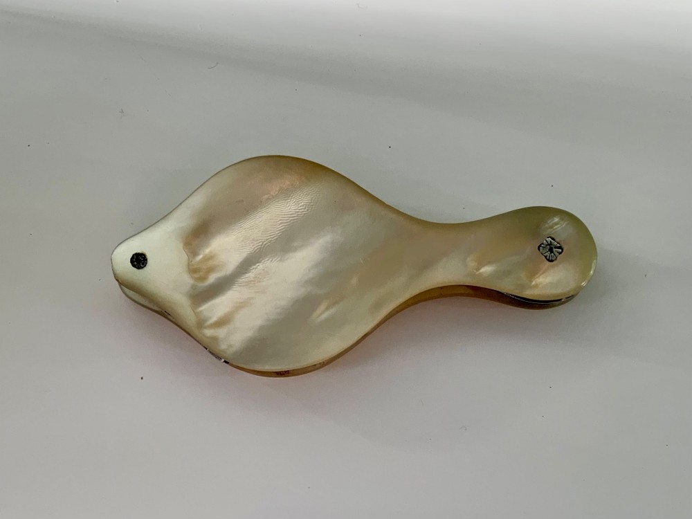 A Georgian folding pocket magnifying glass encased in iridescent cream mother of pearl plates with silver rivets. View II