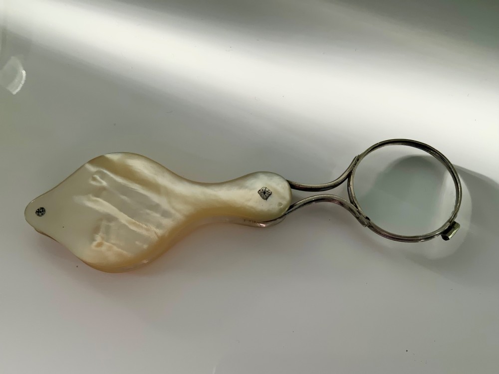 A Georgian folding pocket magnifying glass encased in iridescent cream mother of pearl plates with silver rivets. View III