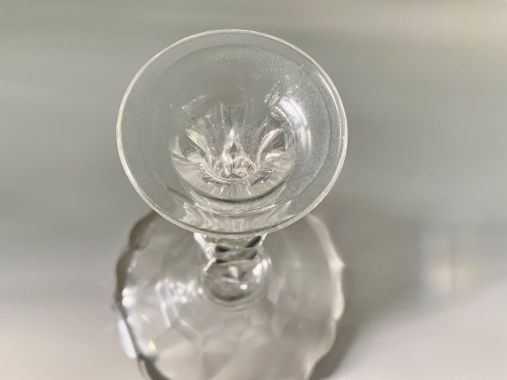 A Georgian clear glass taper stick featuring a faceted knopped stem and a scalloped, facet-cut domed base. View IV