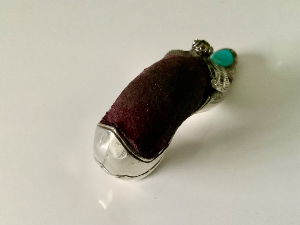 A Victorian silver shoe-shaped pin cushion embellished with hand engraving, set agate stones, and a dark velvet cushion top. View III