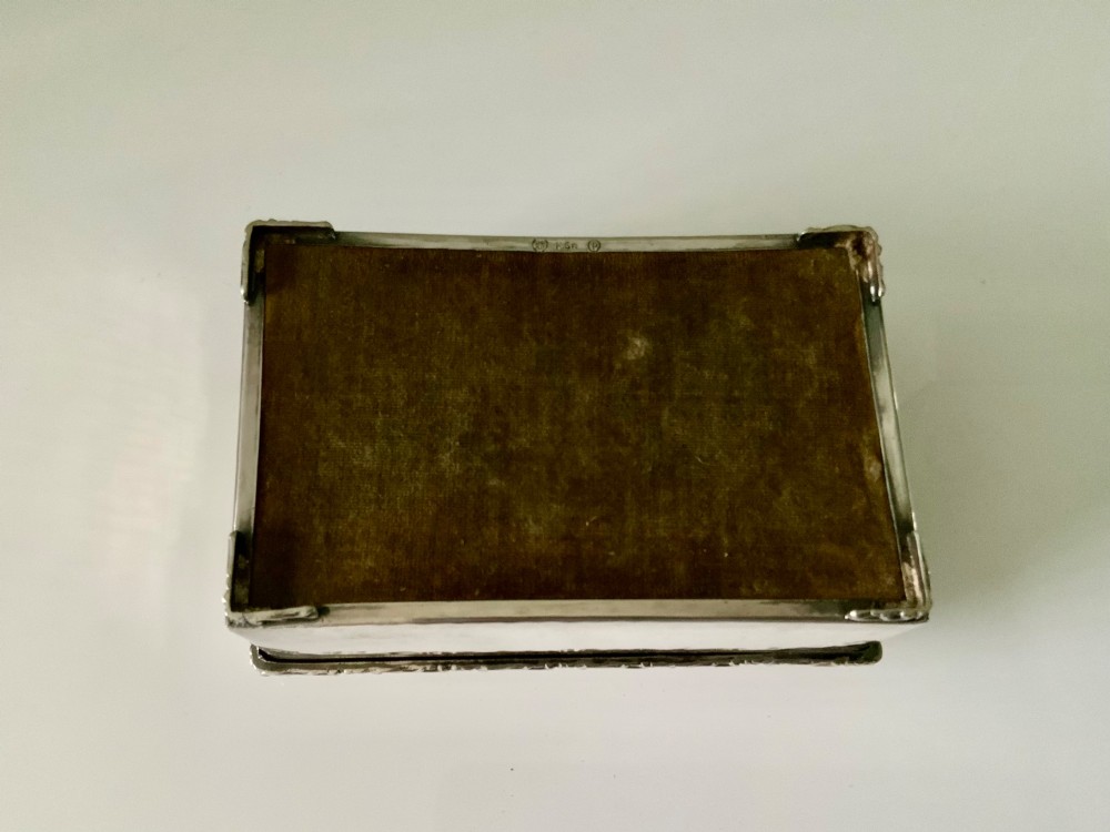 A rectangular silver plated box featuring a hand-hammered lid and a dark oval central inset framed by decorative detailing. View II