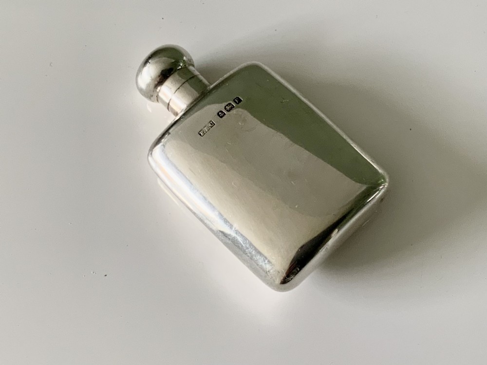 A hallmarked sterling silver combination scent bottle and powder compact with a hinged lid revealing an inner well alongside a small fabric powder puff. View V