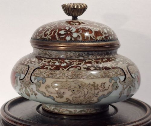fig 1. A Japanese cloisonne enamel koro decorated with phoenix motifs and intricate floral scrollwork, topped with a domed lid and carved finial.