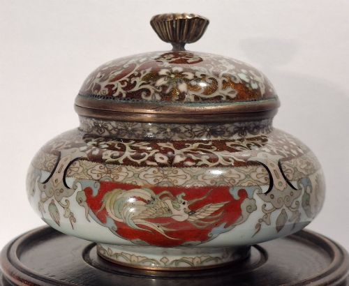 fig 2. A Japanese cloisonne enamel koro decorated with phoenix motifs and intricate floral scrollwork, topped with a domed lid and carved finial.