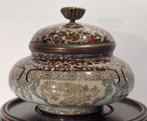fig 3. A Japanese cloisonne enamel koro decorated with phoenix motifs and intricate floral scrollwork, topped with a domed lid and carved finial.