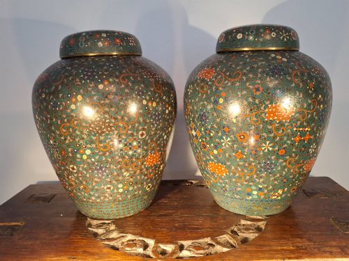 fig 1. A pair of rounded Japanese cloisonne enamel ginger jars decorated with dense green foliage scrollwork and colourful floral motifs with domed lids.