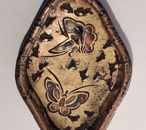fig 1. An oval-shaped antique Japanese bronze recessed door pull featuring two decorative enamel butterflies against a textured gilded background.