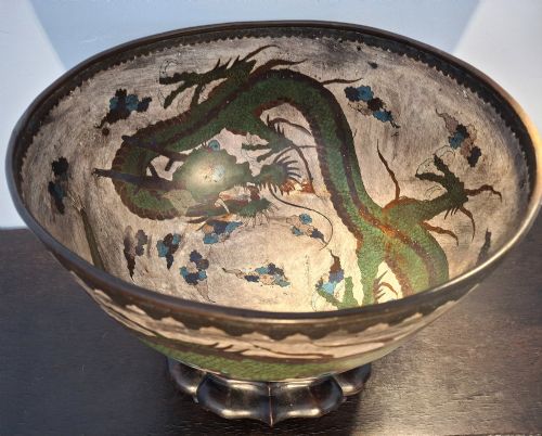 fig 1. A large Japanese cloisonne enamel bowl featuring green dragon motifs, displayed on a carved dark wooden stand.