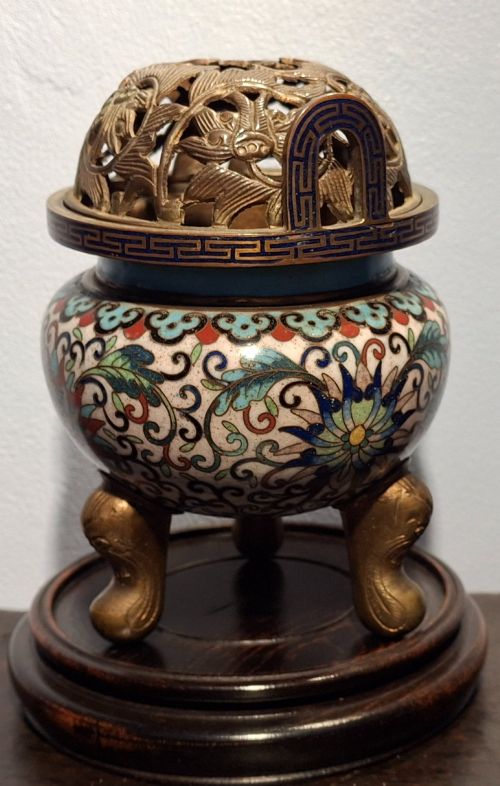 fig 1. A 19th-century Chinese tripod cloisonne enamel censer featuring intricate floral scrollwork, upright loop handles, three gilded cabriole feet, and a pierced brass cover.