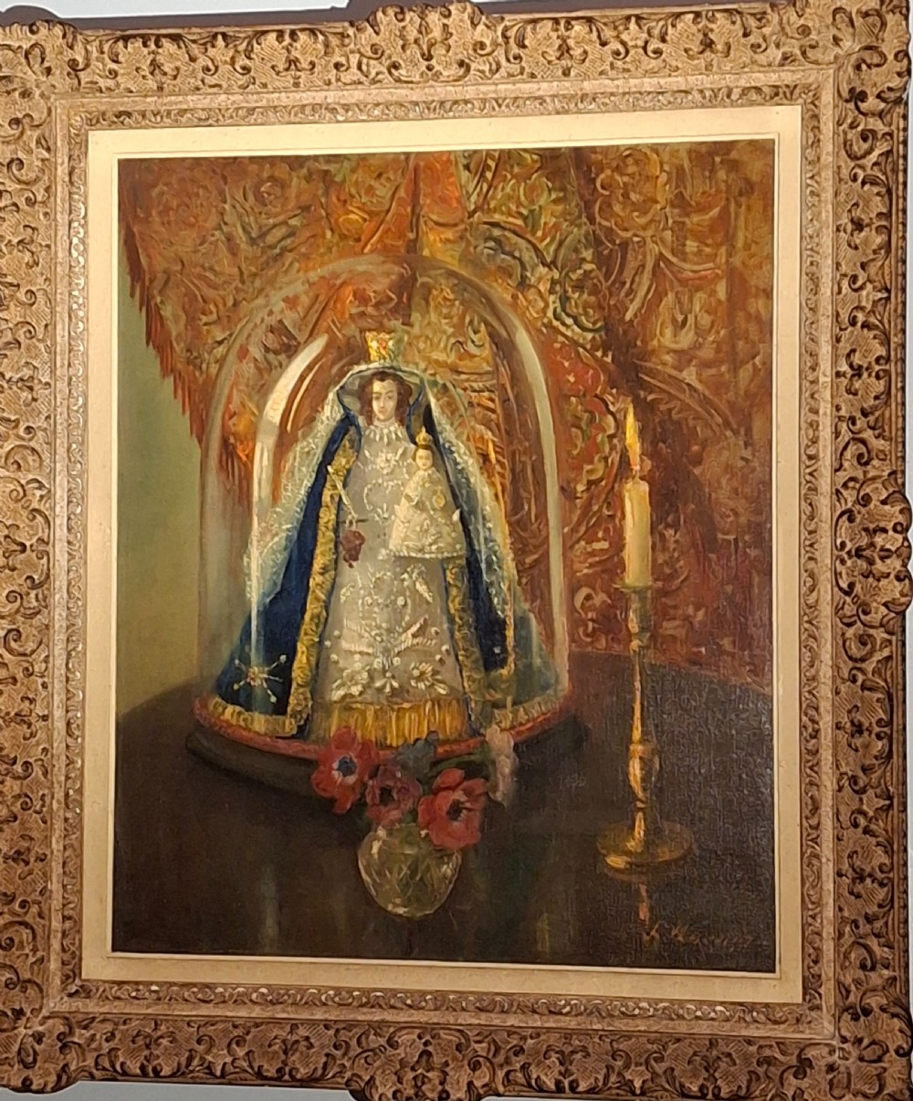 A framed 19th-century oil painting depicting a statue of the Madonna and Child beneath a glass cloche, flanked by a candle and a small vase of flowers. View II