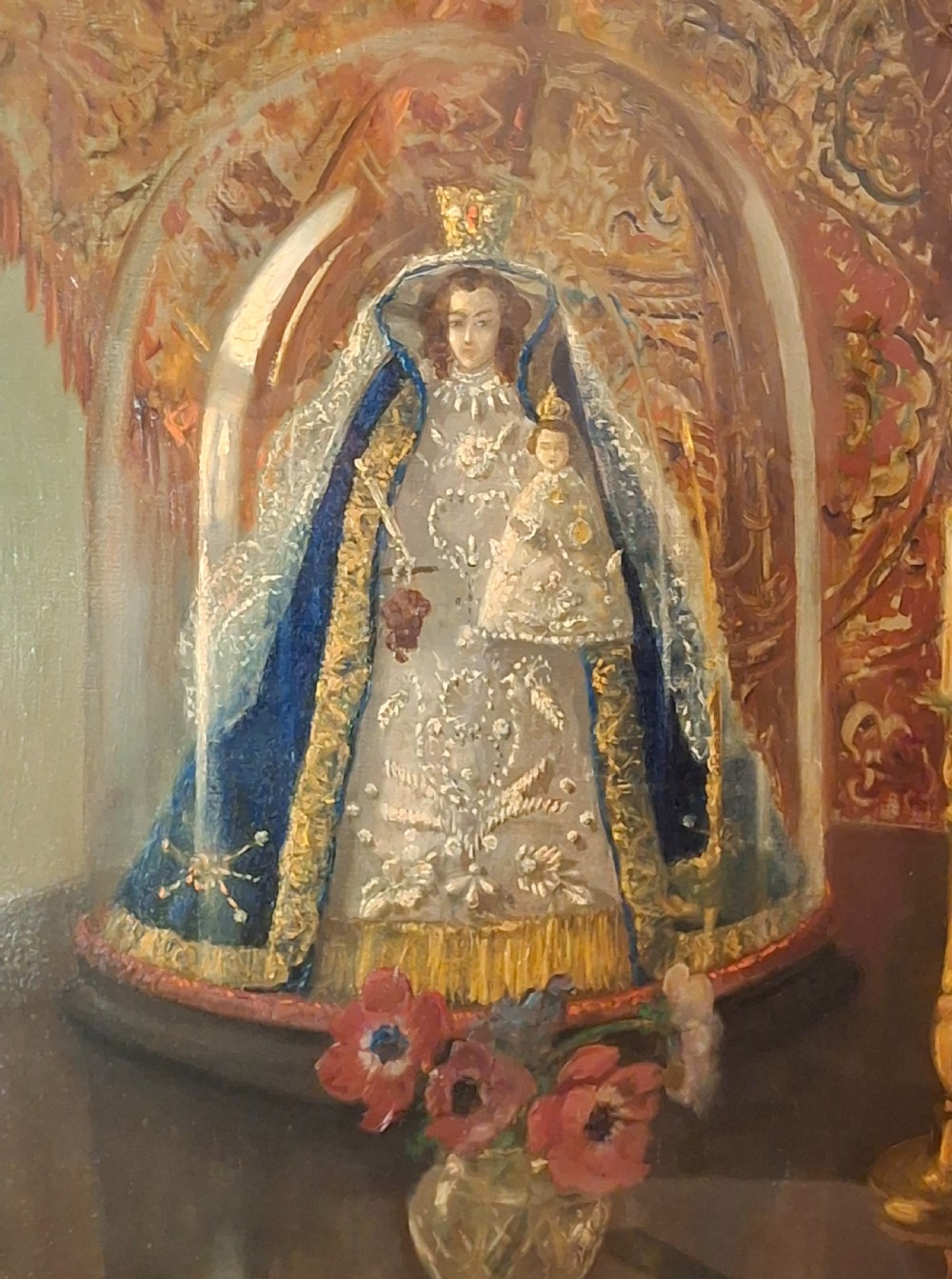 A framed 19th-century oil painting depicting a statue of the Madonna and Child beneath a glass cloche, flanked by a candle and a small vase of flowers. View V