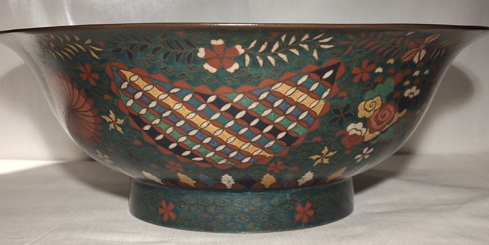 A large late 19th-century Japanese cloisonne enamel bowl featuring polychrome floral patterns and geometric motifs on a dark green ground. View XIV