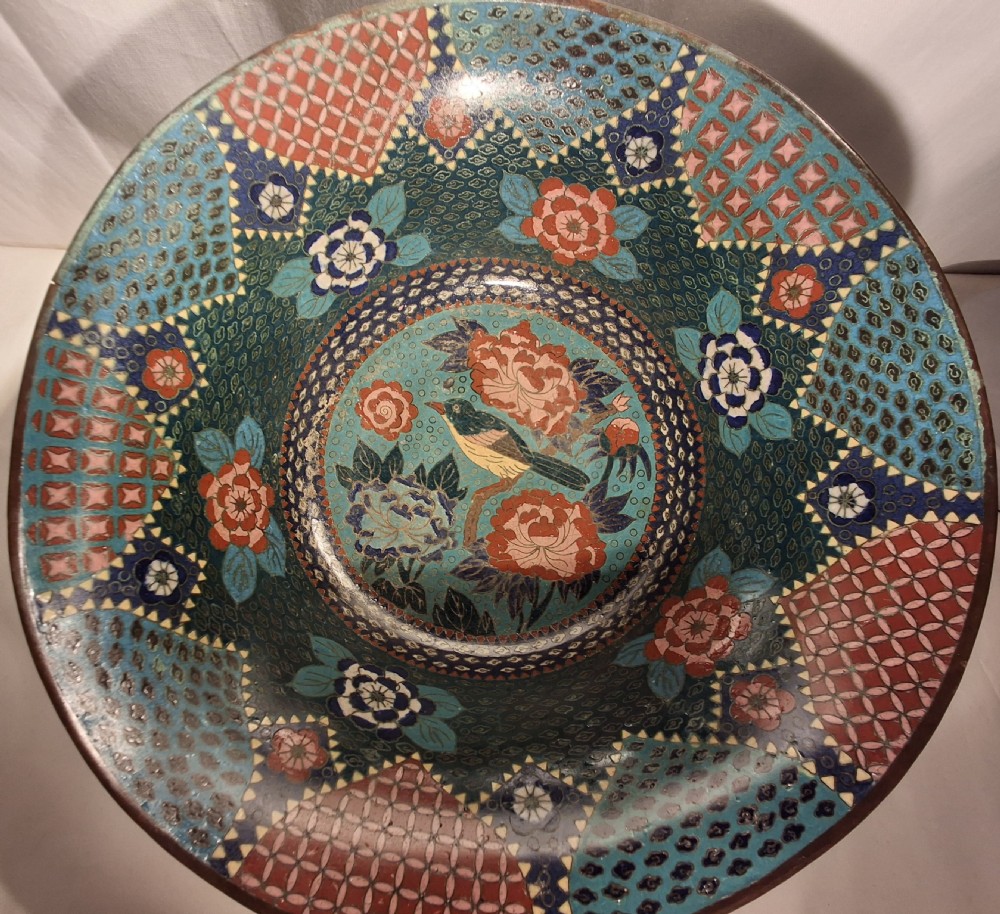 A flared antique Japanese cloisonne enamel bowl featuring a teal ground with fine brass wirework forming floral patterns in coral, pink, and blue. View II