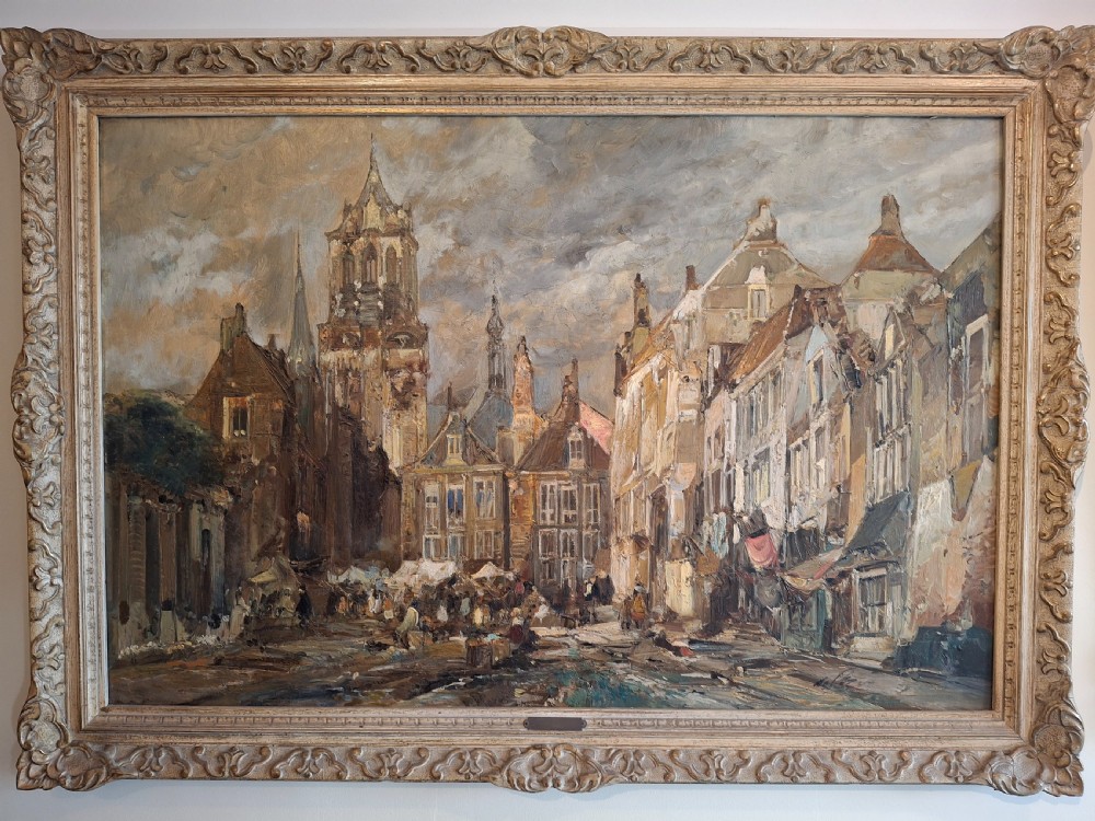 A mid-century oil painting depicting a historic Ghent street and town square with traditional architecture, enclosed within an ornate gilded frame.