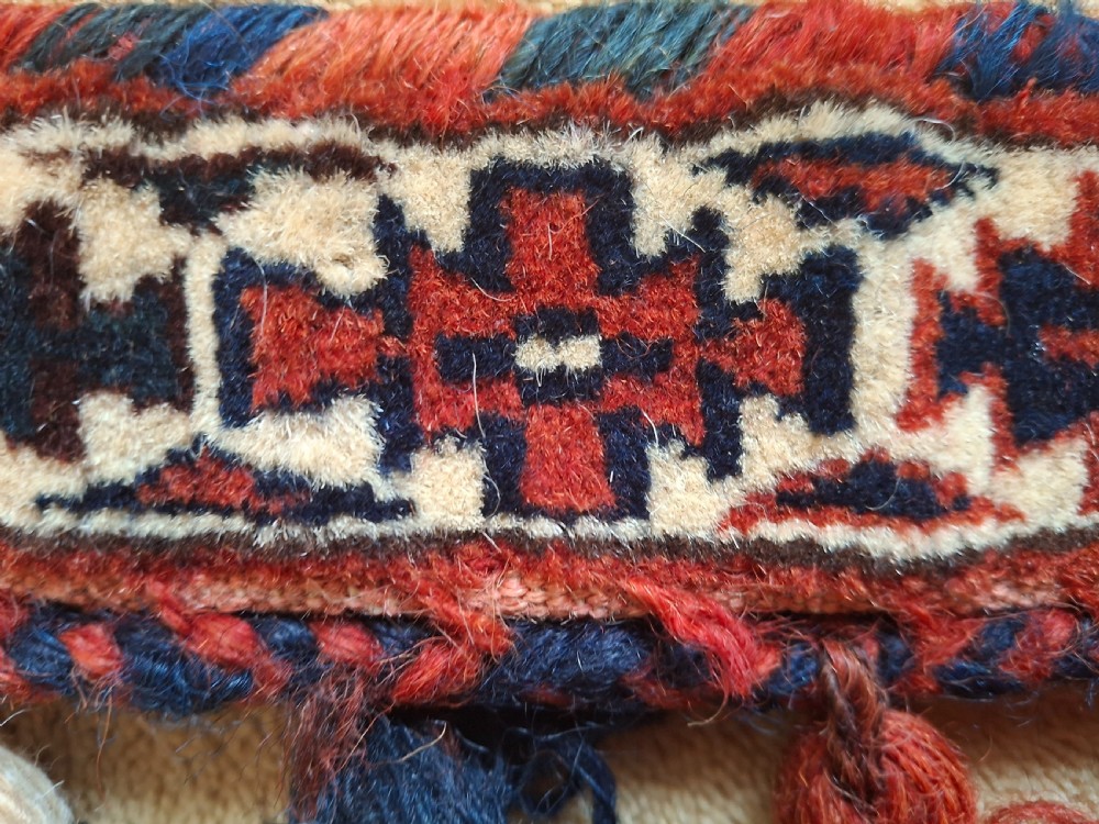 A pair of handwoven wool Turkoman camel neck trappings featuring geometric red and cream bands trimmed with dense multicoloured tassels. View VII